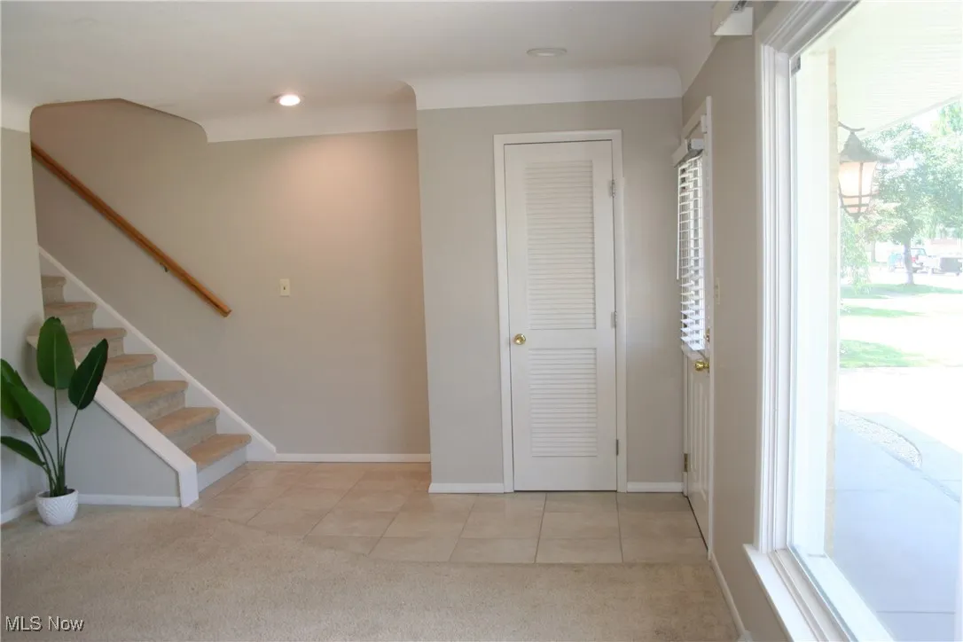 Entryway featuring light carpet, light tile patterned flooring, stairs, and recessed lighting