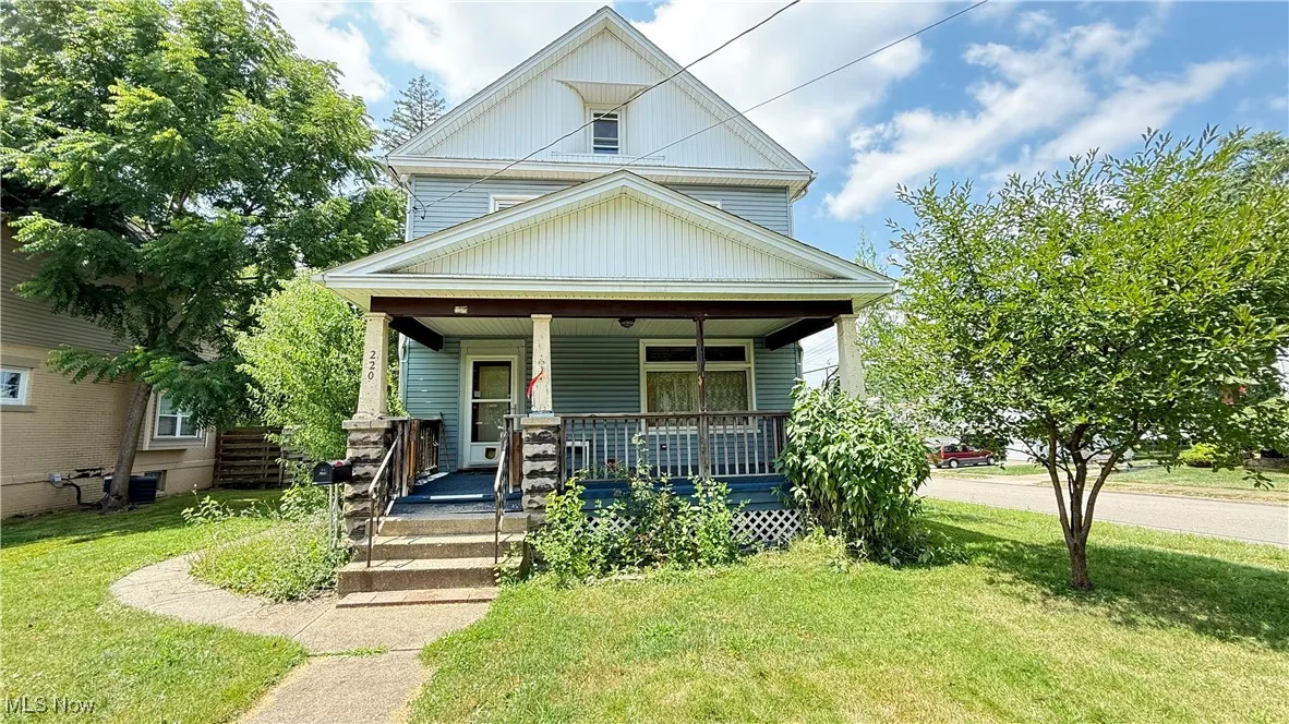 View of front of property with covered porch and a front yard