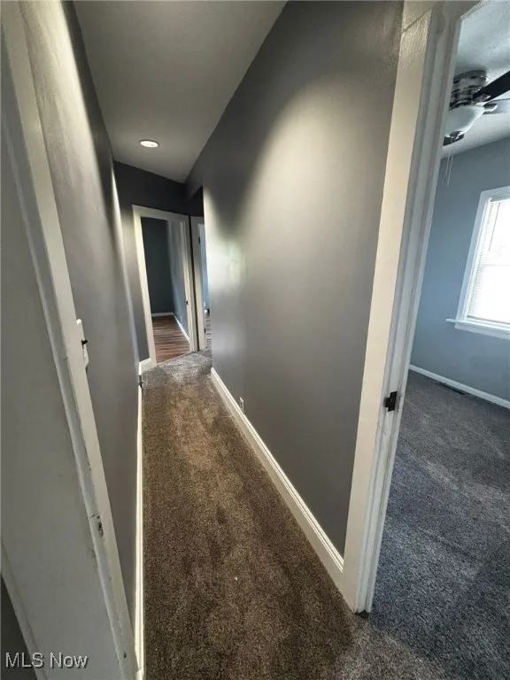 Hall with carpet floors and baseboards