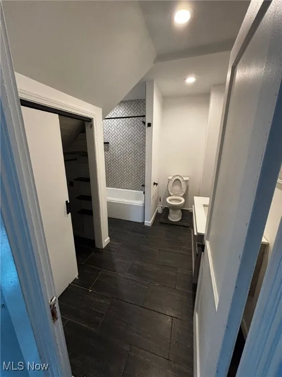 Bathroom with vanity, shower / bath combination, recessed lighting, and wood tiled floors
