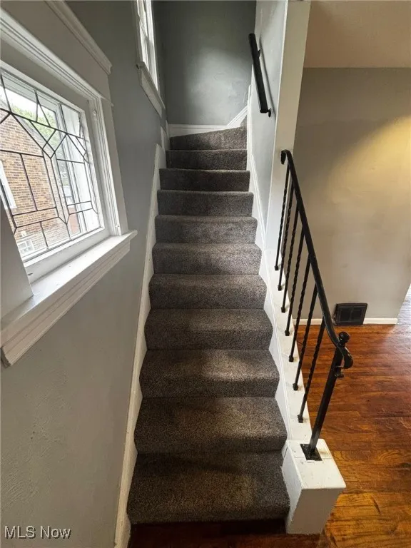 Stairs featuring wood finished floors and baseboards