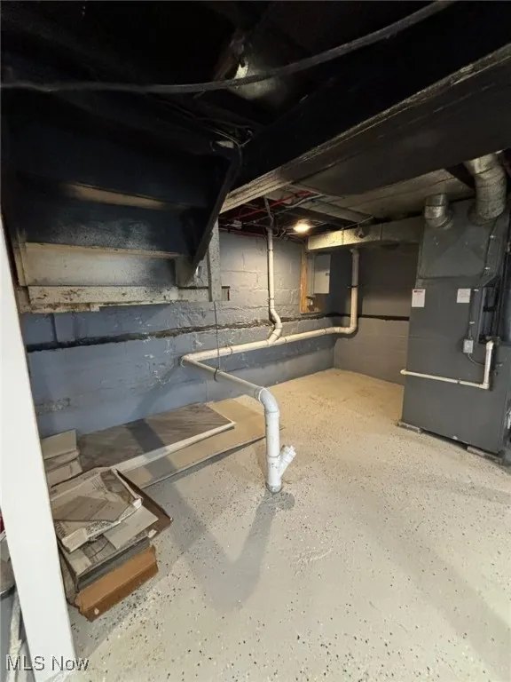 Unfinished basement featuring heating unit