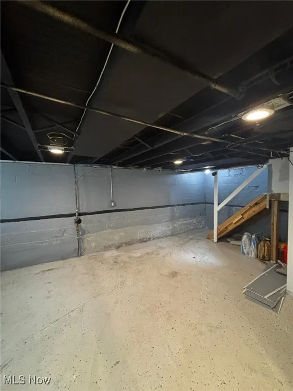 Unfinished below grade area featuring stairs