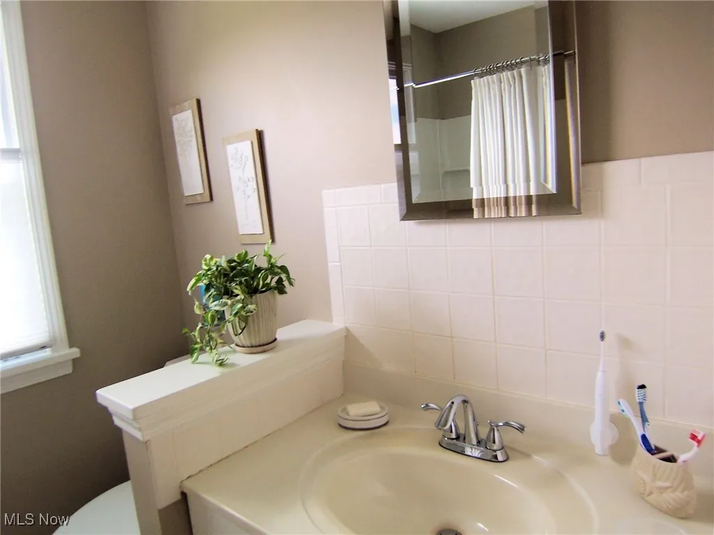 Full bath featuring vanity and curtained shower