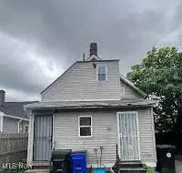Back of property with entry steps and a chimney