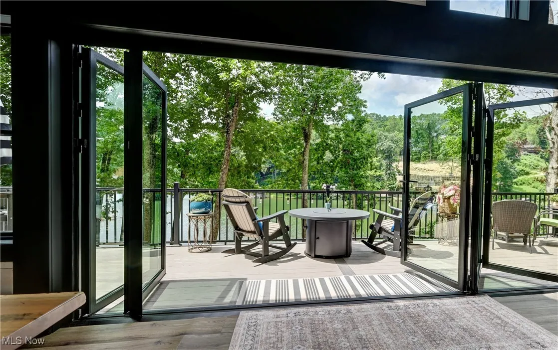 Accordion Doorway to outside featuring wood finished floors and view of scattered trees