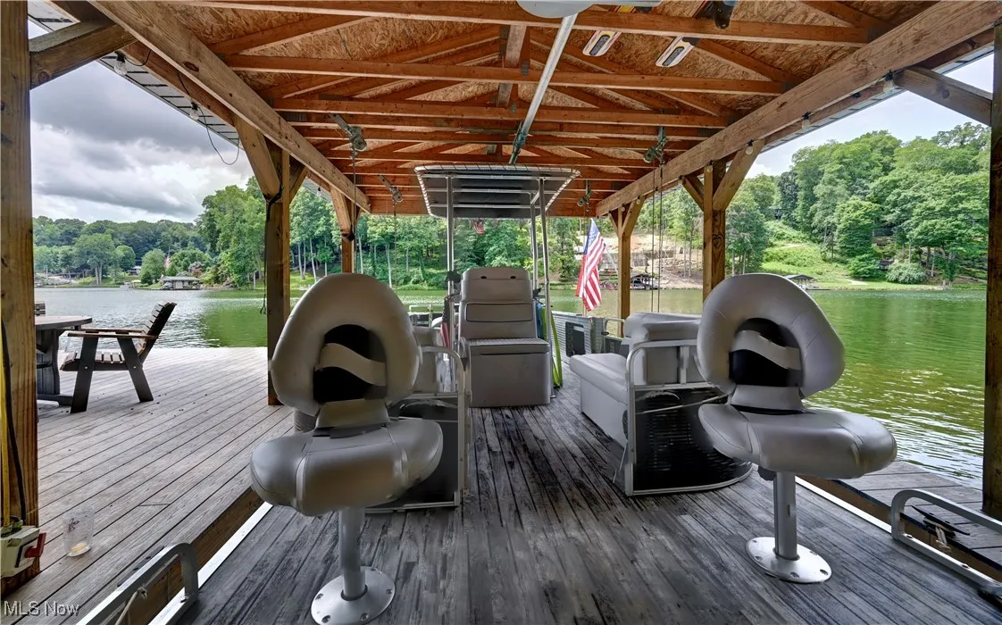 boat dock, a water view, a wooded view, and boat lift