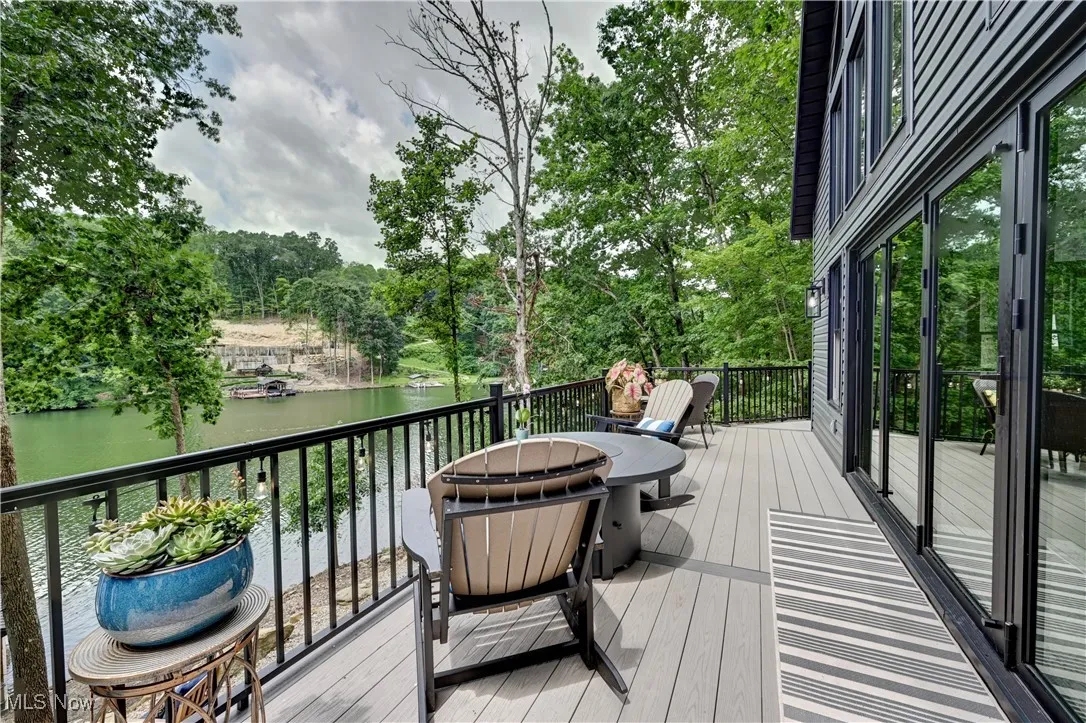 Deck with a water view and view of scattered trees