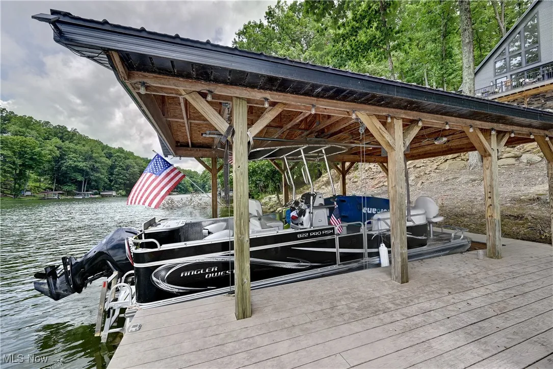 Dock area with a water view, a wooded view, and boat lift