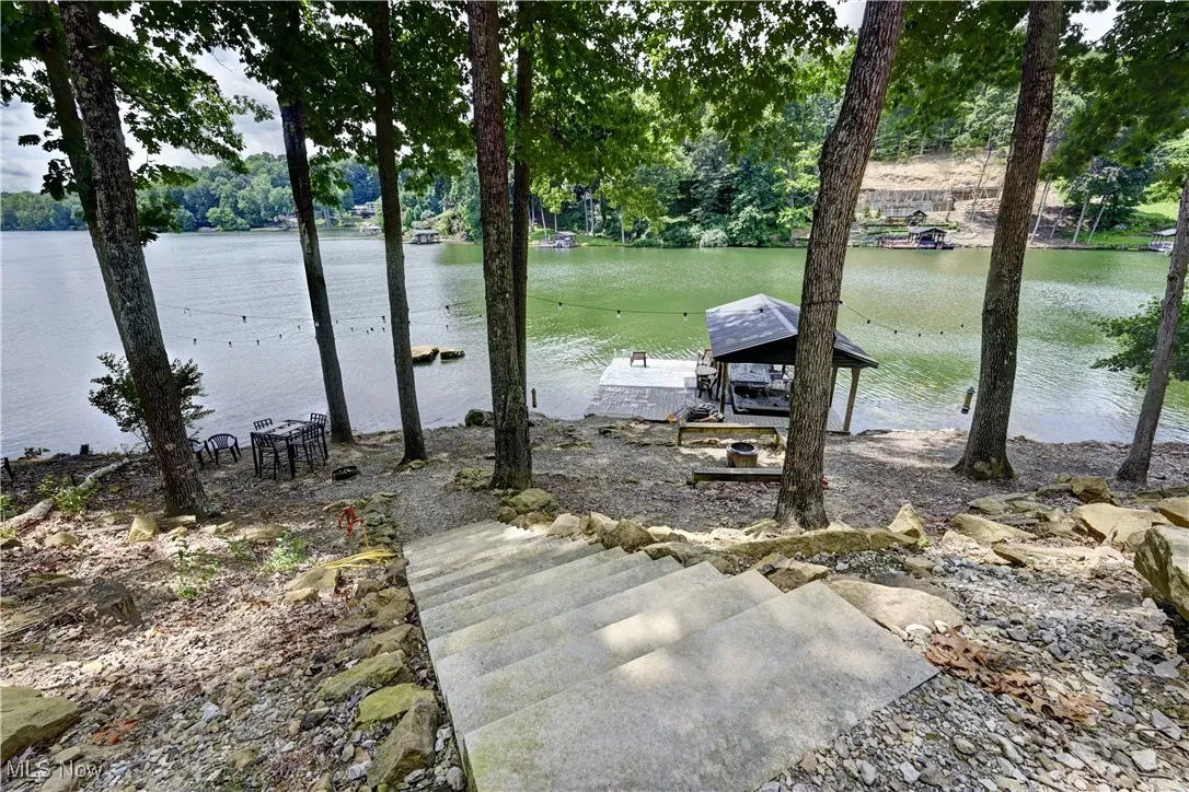 Dock area featuring a water view and concrete steps