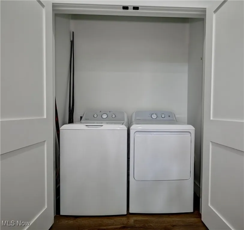 Laundry area with separate washer and dryer and dark wood finished floors