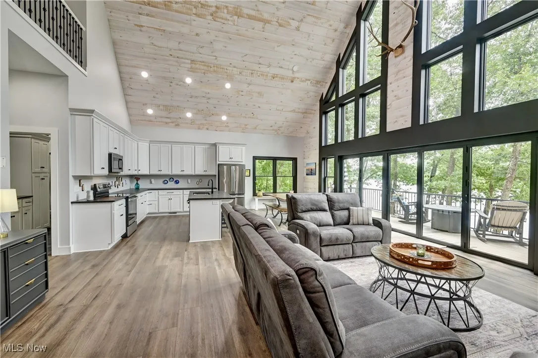 Living area with high vaulted ceiling, wood ceiling, recessed lighting, and light wood-type flooring