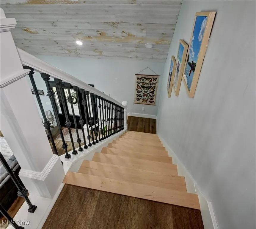 Stairway featuring wood finished floors and baseboards
