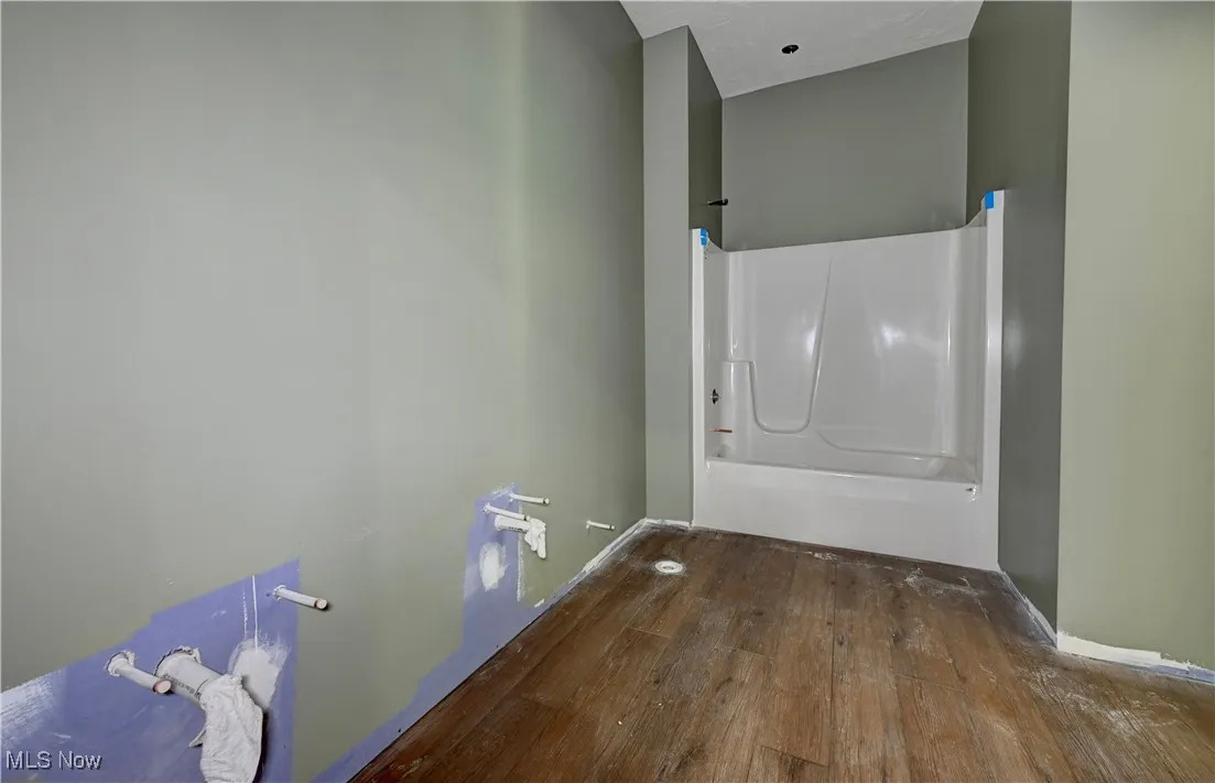 Basement Full bath featuring hardwood / wood-style flooring