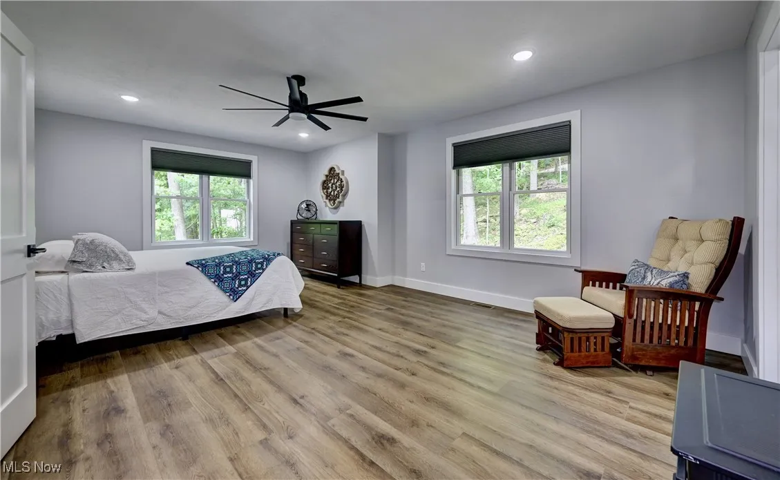 Master bedroom on 2nd floor featuring multiple windows, wood finished floors, recessed lighting, and ceiling fan