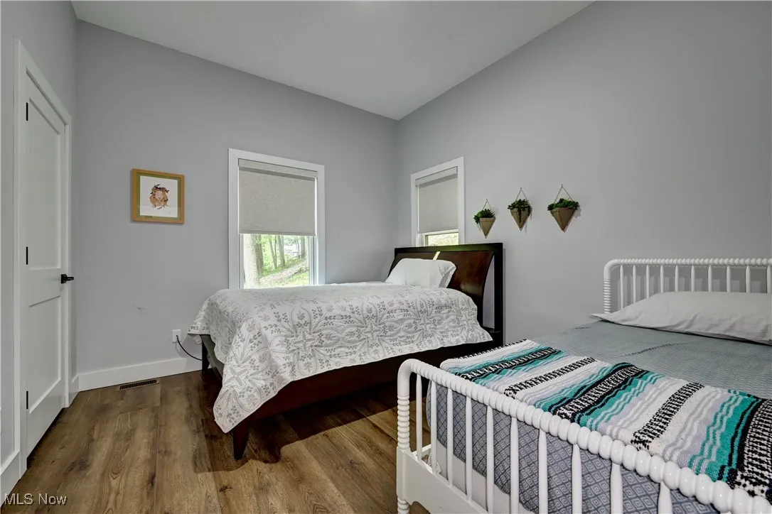 Main floor Bedroom with wood finished floors and baseboards