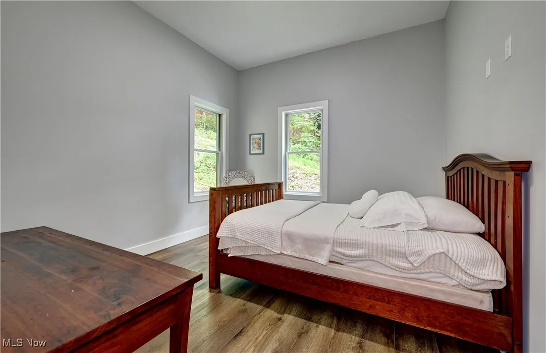 Main floor Bedroom featuring wood finished floors and baseboards