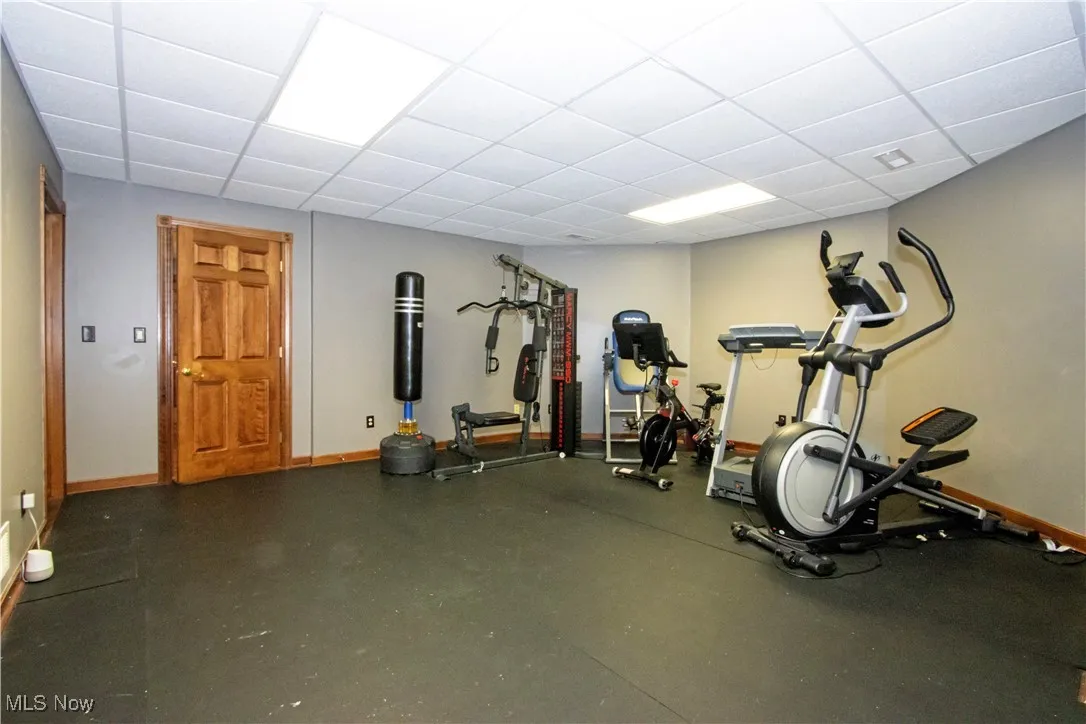 Workout room featuring baseboards and a paneled ceiling