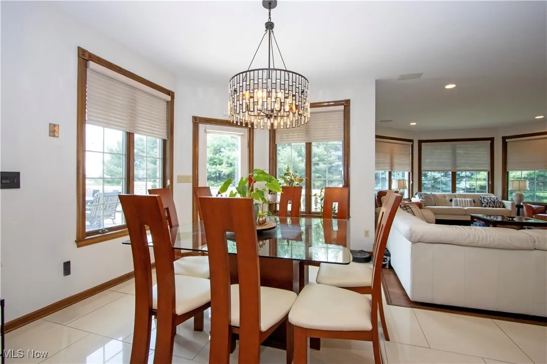 Dining area with a chandelier, healthy amount of natural light, recessed lighting, and light tile patterned floors