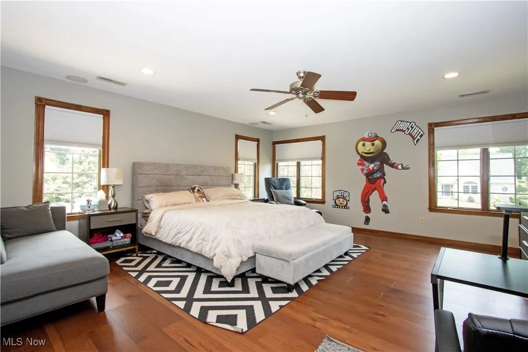 Bedroom with multiple windows, wood finished floors, recessed lighting, and a ceiling fan