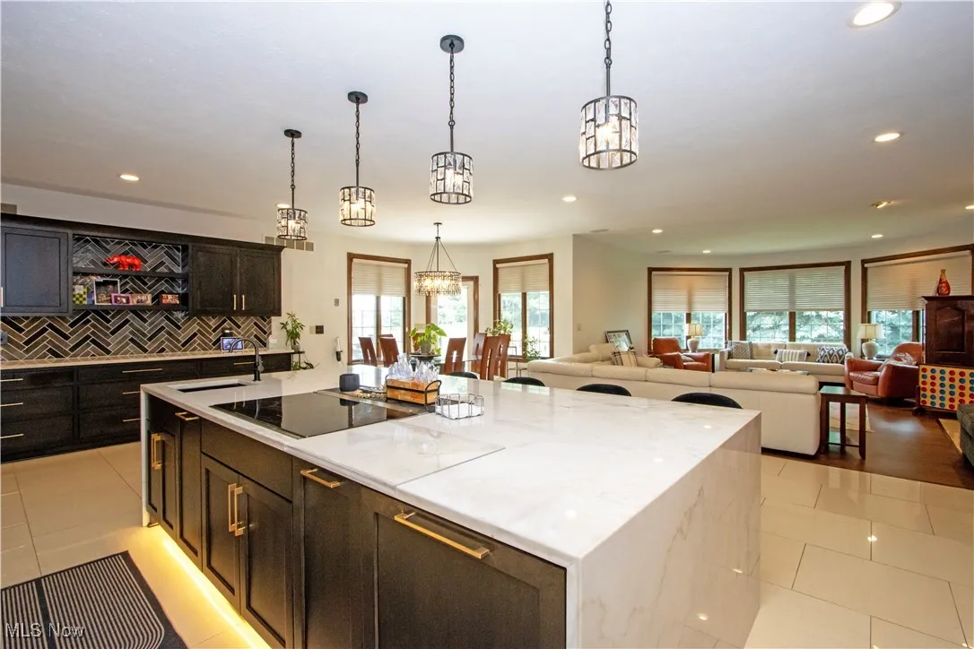 Kitchen with open floor plan, light tile patterned floors, recessed lighting, a spacious island, and decorative backsplash