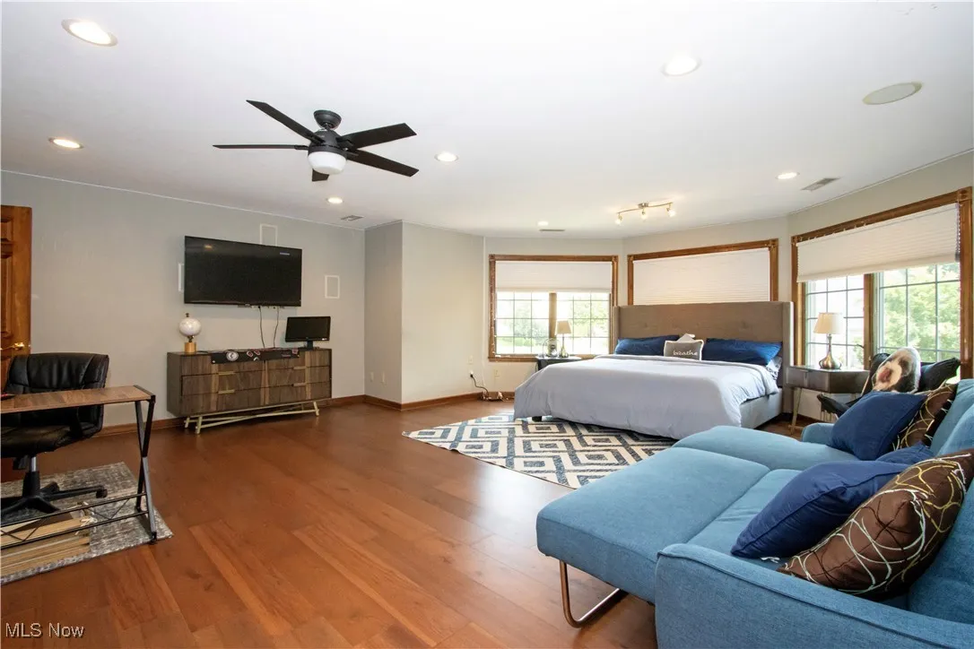 Bedroom with multiple windows, wood finished floors, and recessed lighting