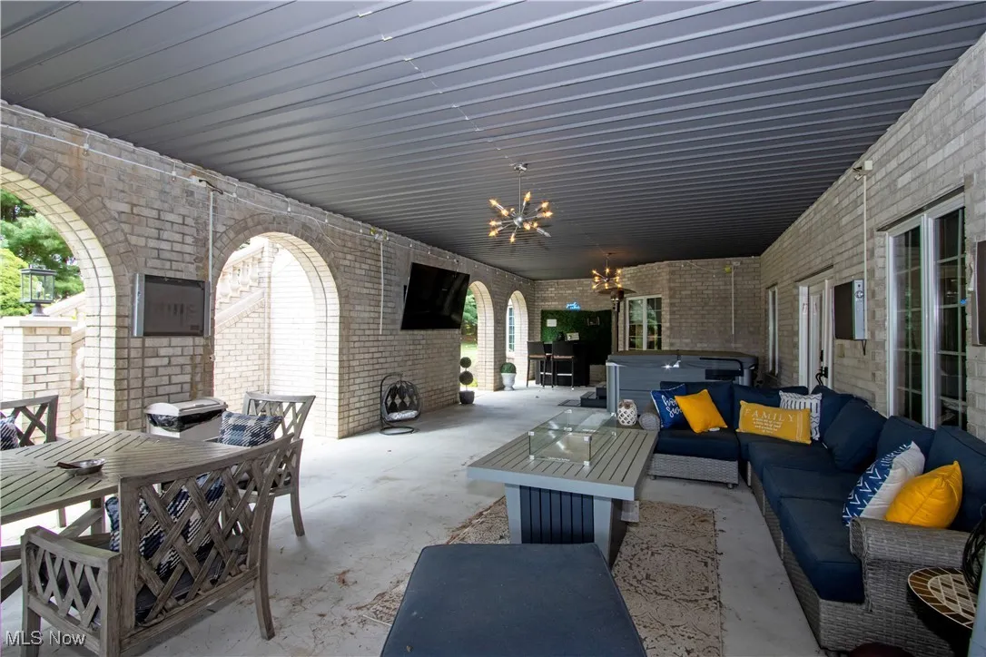 View of patio / terrace with an outdoor hangout area, a hot tub, and outdoor dining space