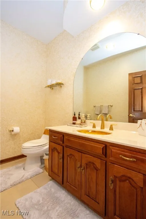 Bathroom featuring vanity, tile patterned flooring, and wallpapered walls