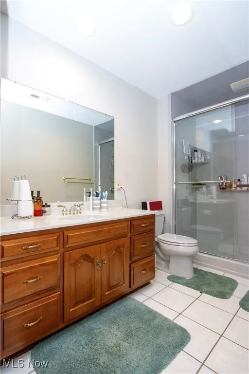 Full bathroom featuring vanity, a stall shower, and tile patterned floors