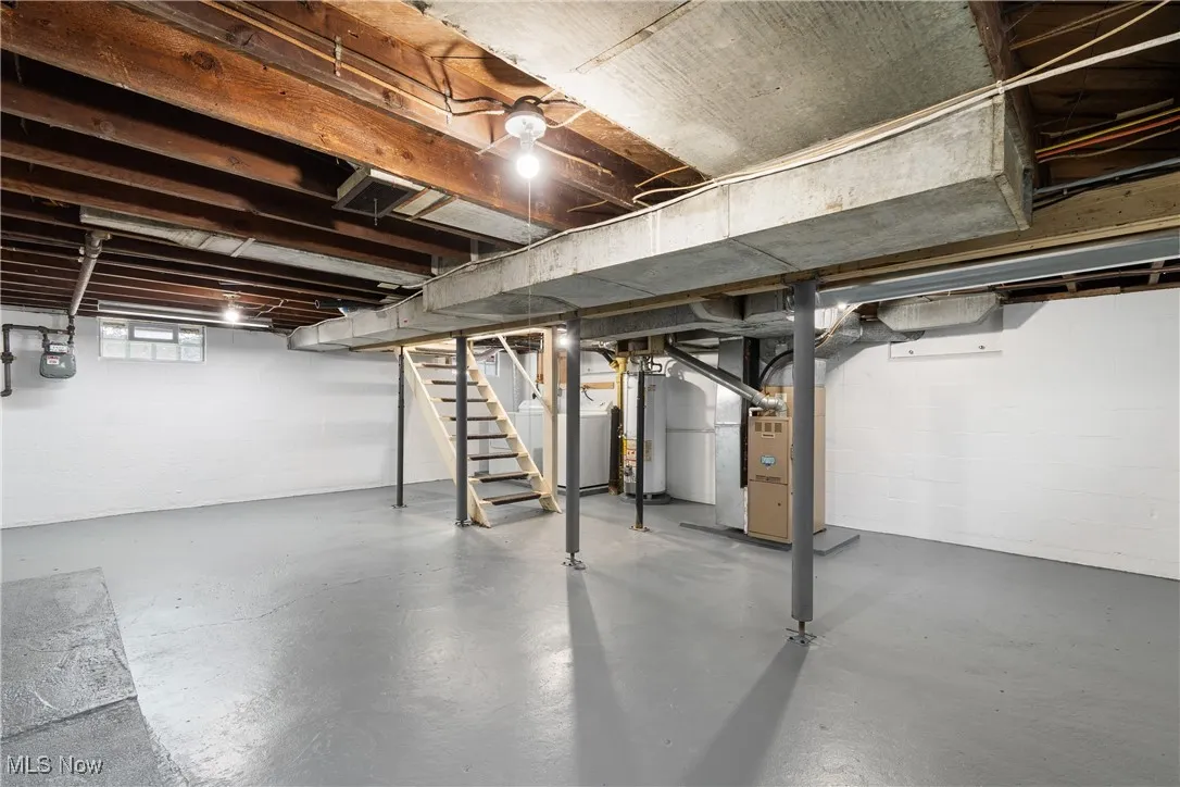 Basement featuring stairway, heating unit, and water heater