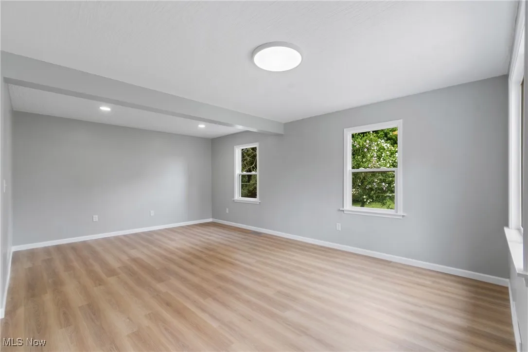 :Living room with plenty of natural light, light wood-type flooring, and recessed lighting
