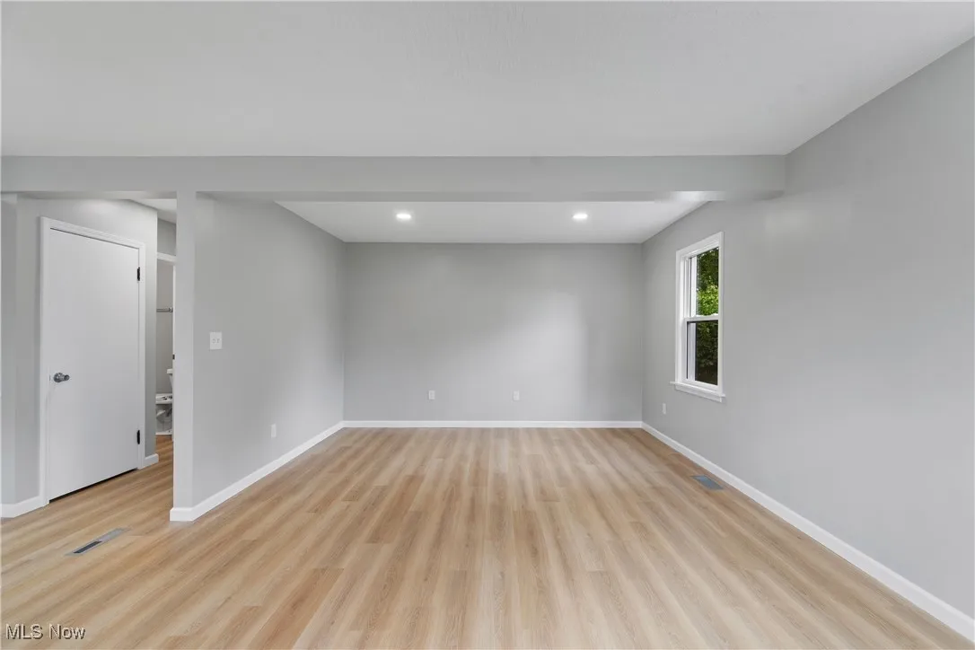 Living room with light wood-type flooring and recessed lighting