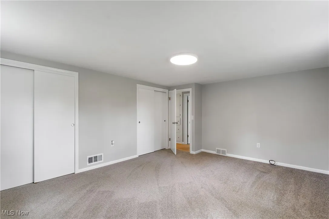 Bedroom featuring two closets and carpet