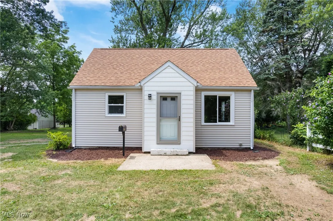 Bungalow-style home with a front lawn and a shingled roof