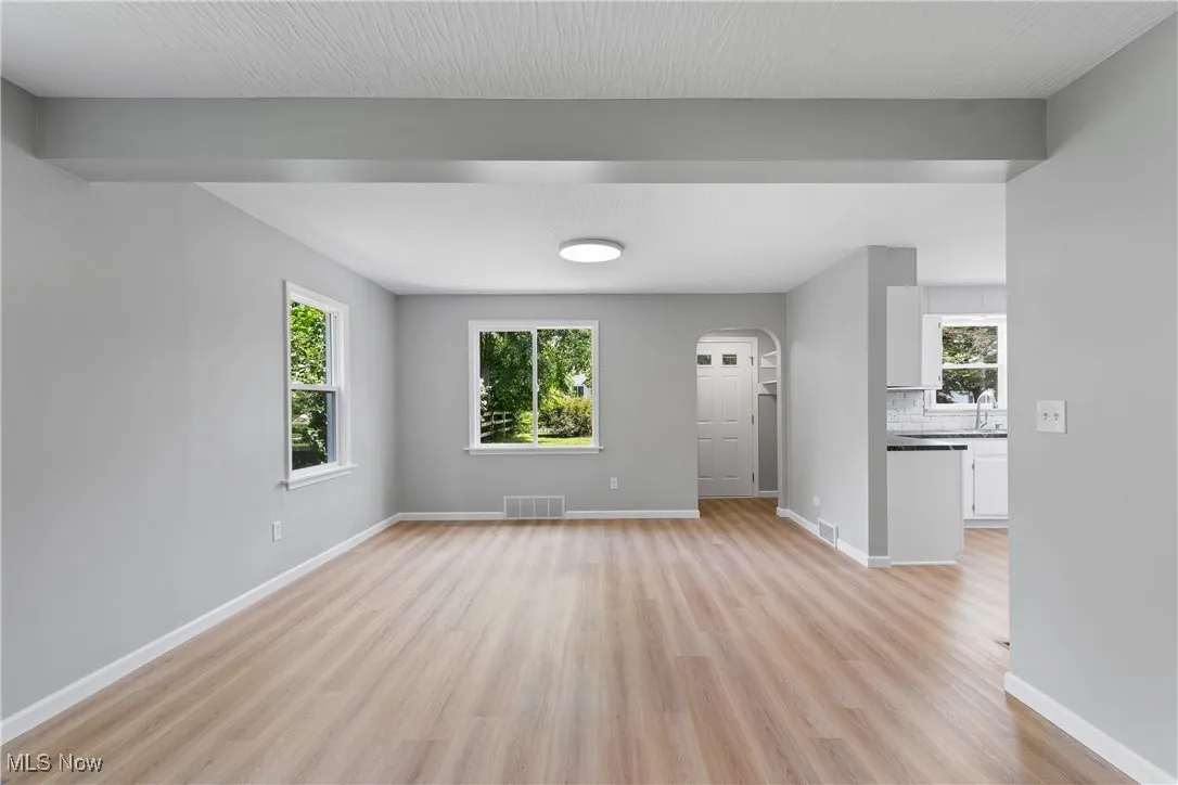 Living room with arched walkways and light wood finished floors