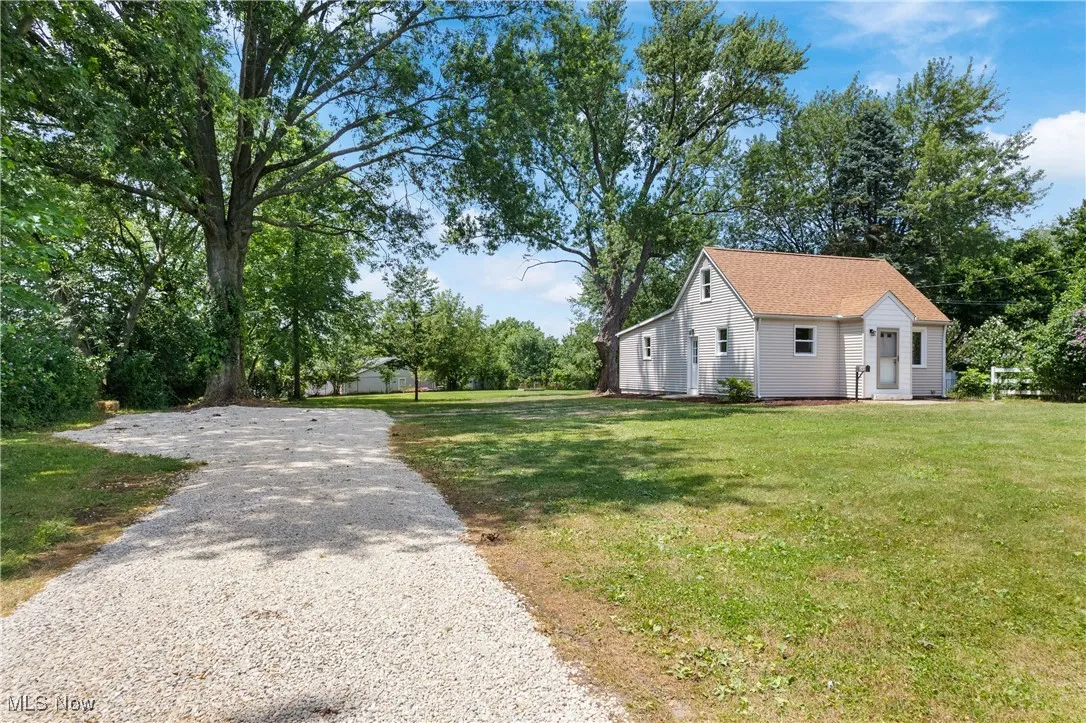 View of home's exterior featuring a yard and gravel driveway