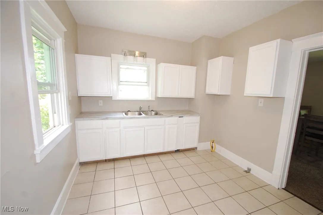 Kitchen with plenty of natural light, light countertops, and white cabinetry