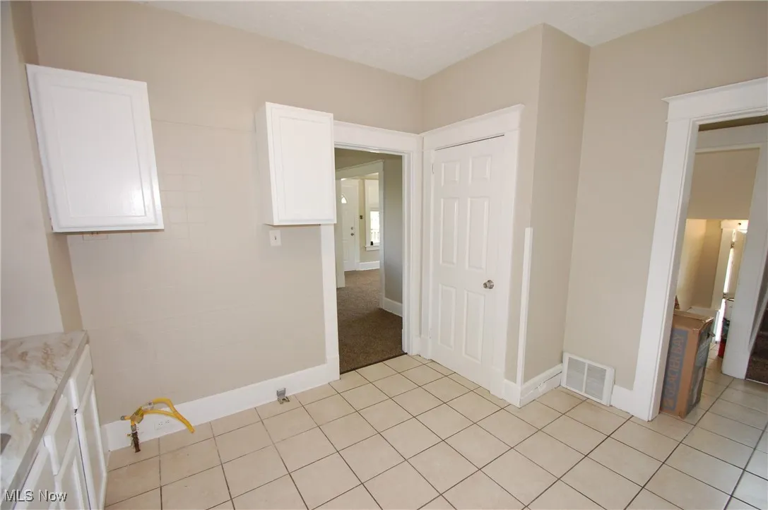 Unfurnished bedroom with light tile patterned floors and baseboards