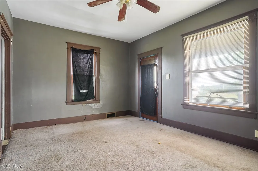 Empty room with carpet and ceiling fan