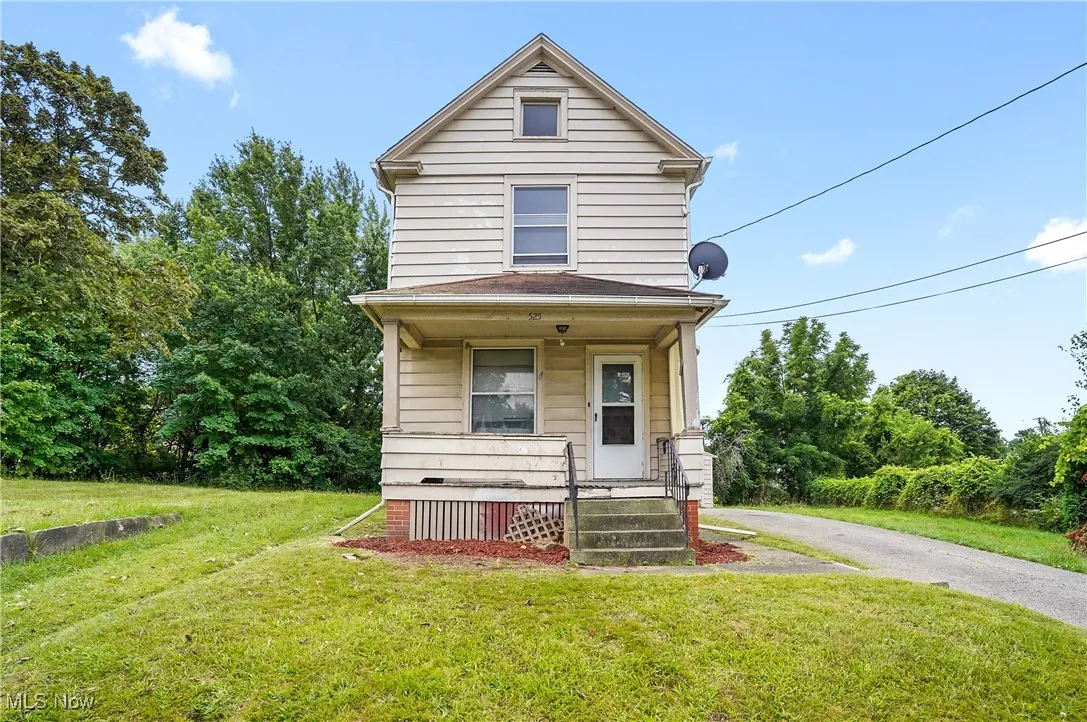 View of front of home with covered porch and a front yard