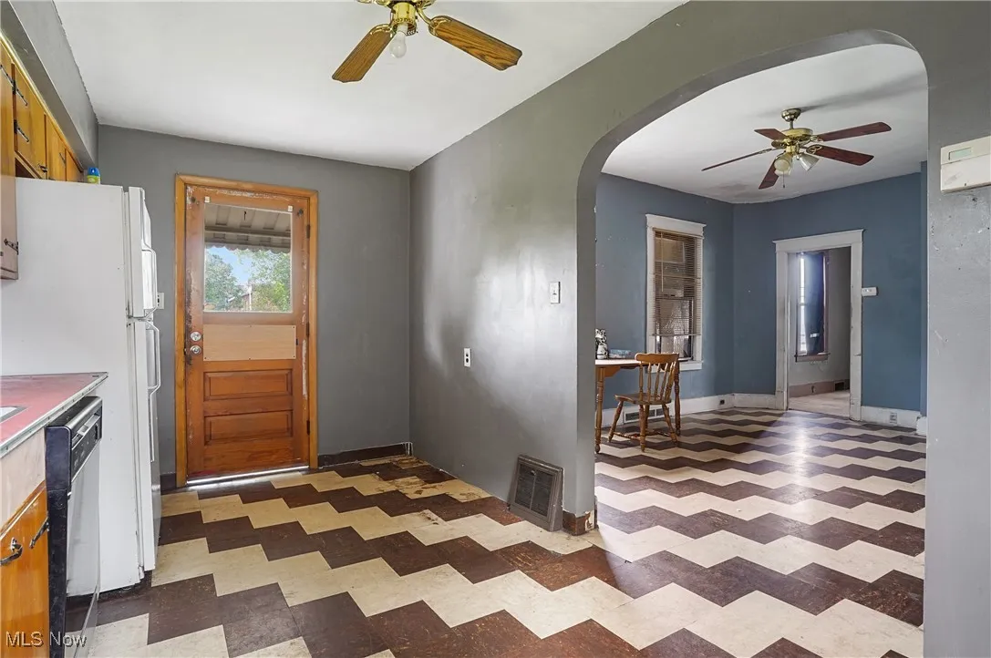 Kitchen featuring a ceiling fan, tile patterned floors, arched walkways, and dishwasher