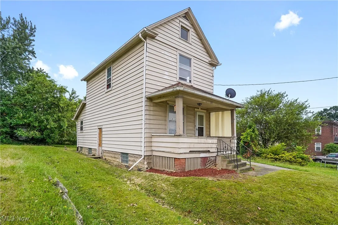 View of front of property featuring covered porch and a front lawn