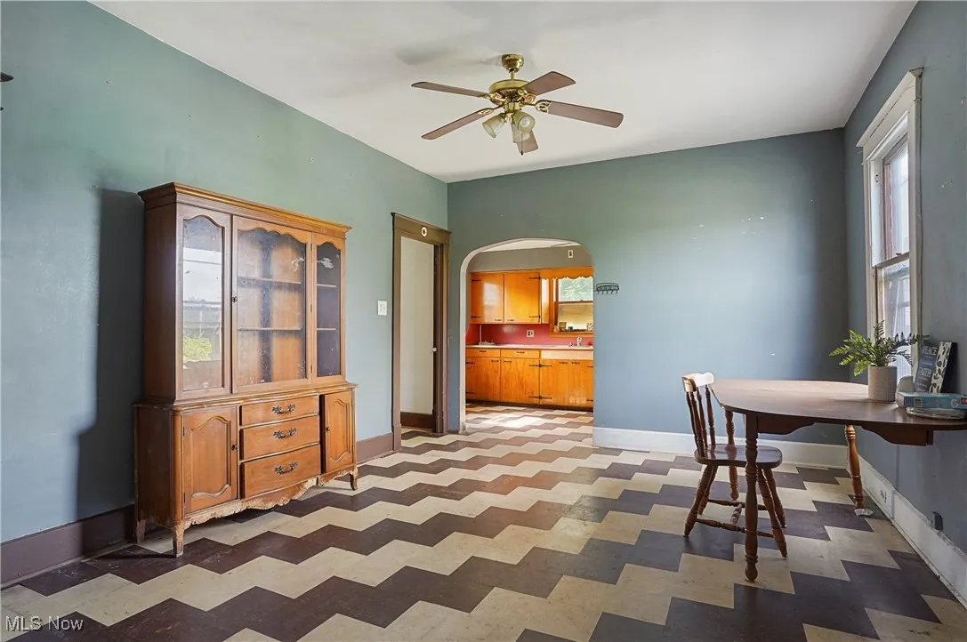 Dining area featuring healthy amount of natural light, tile patterned floors, ceiling fan, and arched walkways