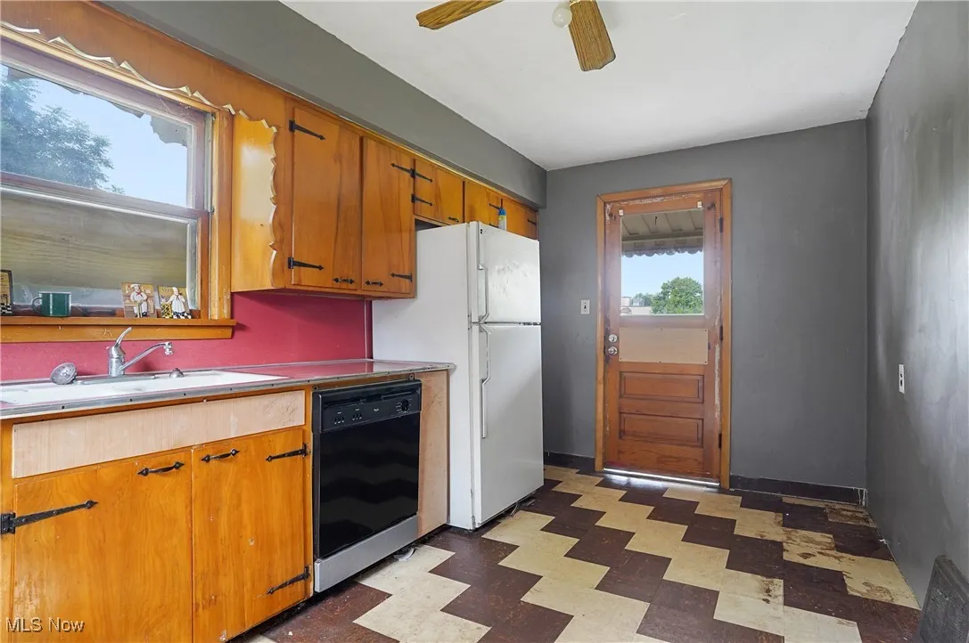 Kitchen with light flooring, dishwasher, a ceiling fan, brown cabinets, and light countertops
