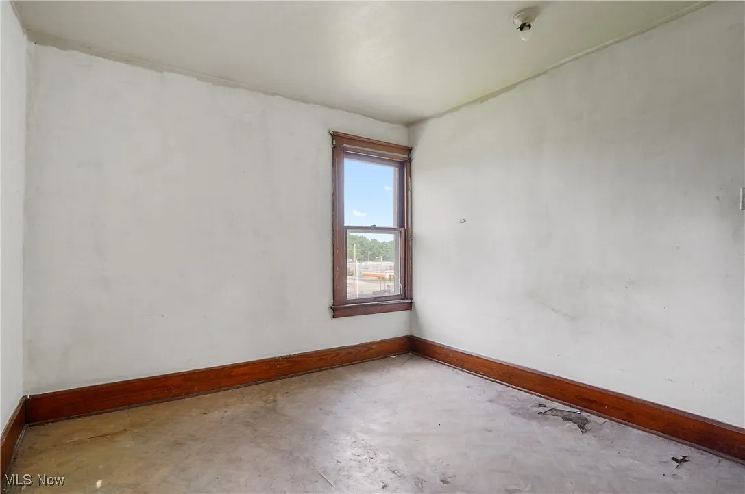 Unfurnished room with baseboards and concrete floors
