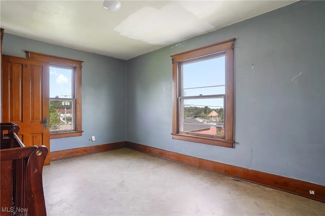 Empty room featuring tile patterned floors and baseboards