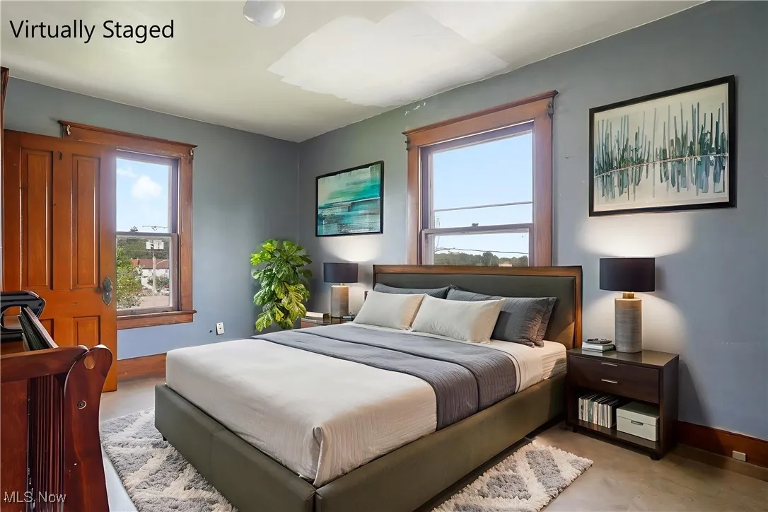 Bedroom featuring multiple windows and concrete floors