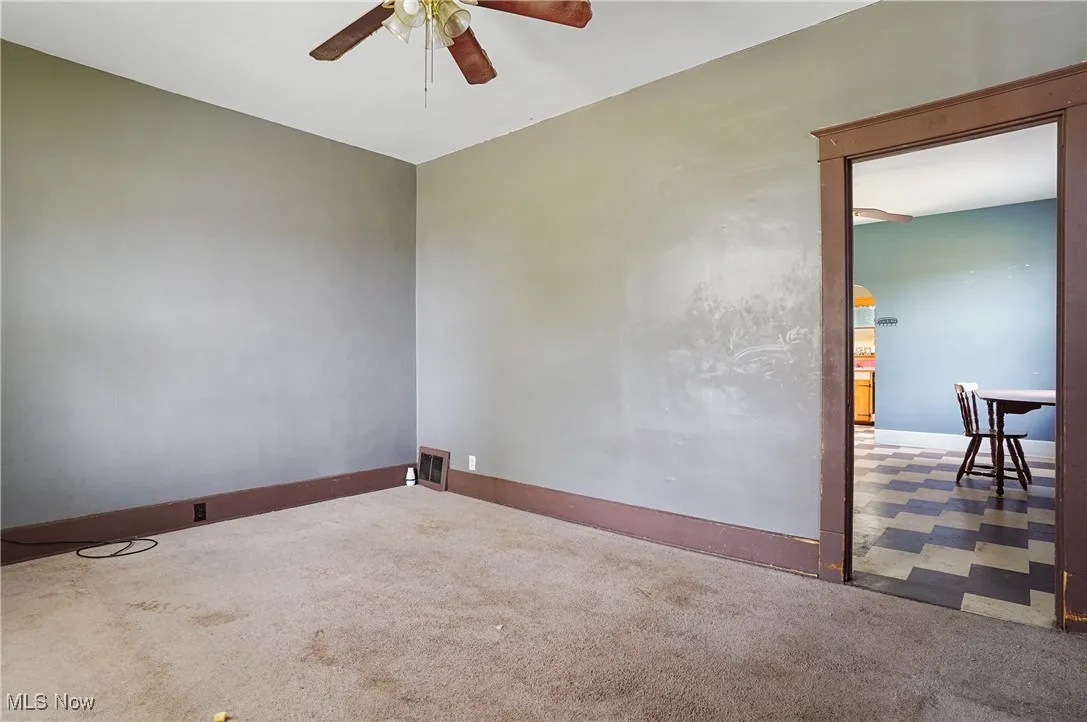 Spare room with a ceiling fan and carpet flooring