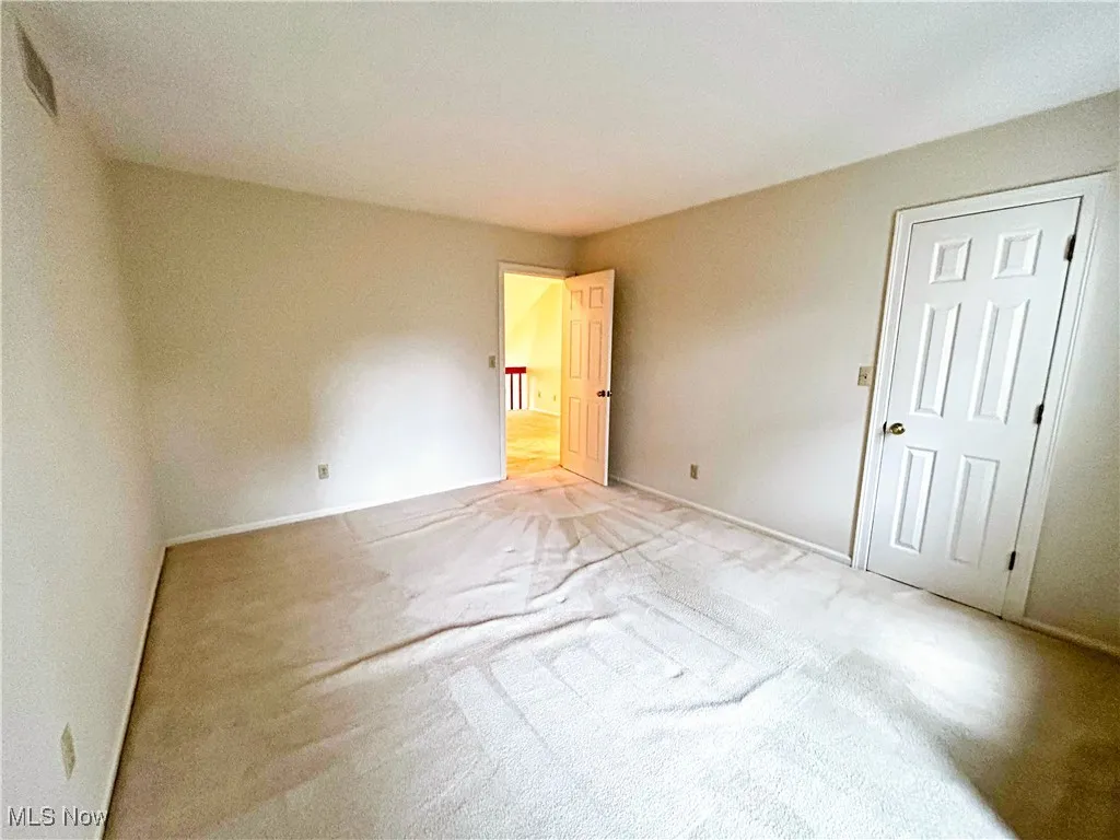 Second bedroom featuring light colored carpet and a walk-in closet