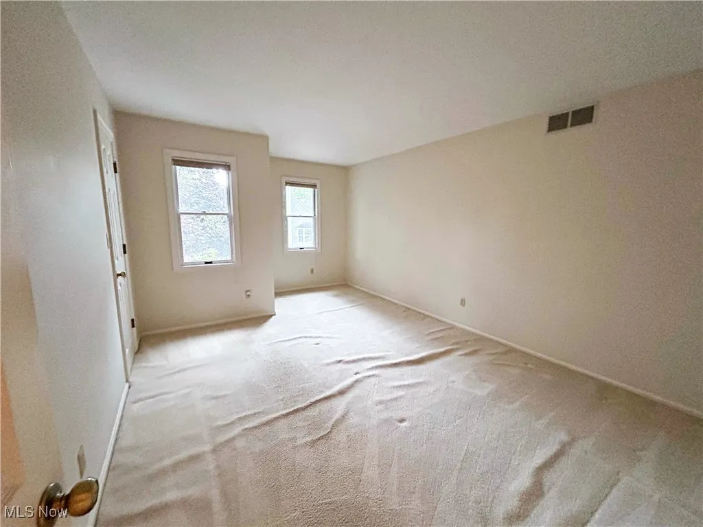 Bedroom featuring windows, and light colored carpet